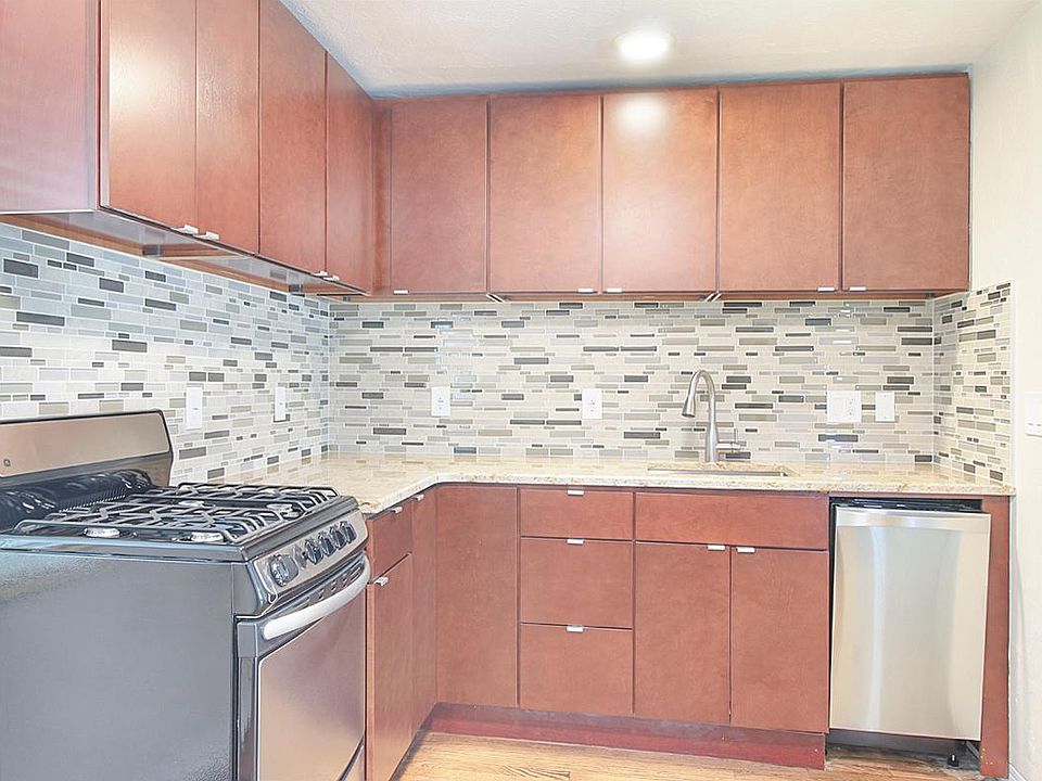 Kitchen has wood cabinets, granite counters, tile backsplash and natural gas cooking.
