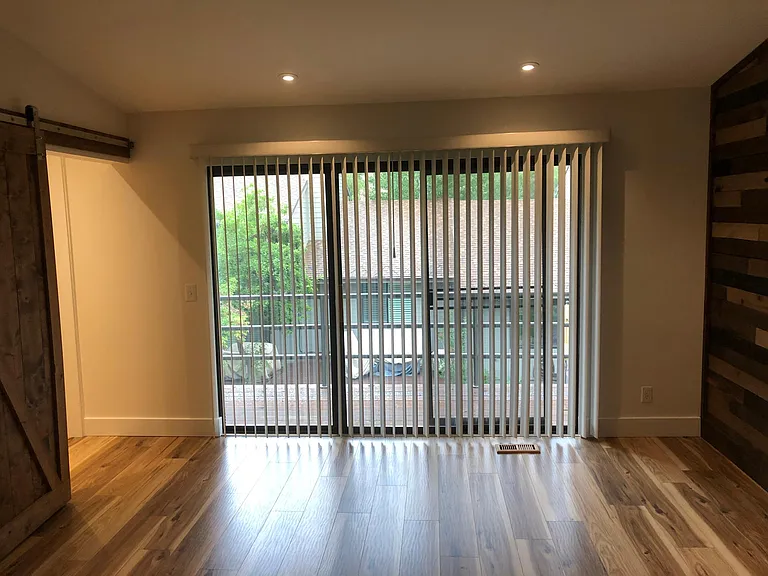 Vertical blinds allow for privacy and the walk-in closet doors are on the left.