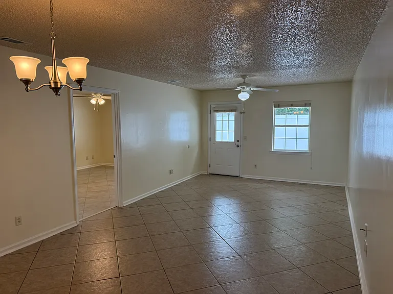 Great room and dining area with master bedroom to the left. Rear door and window lead to your private concreted patio.