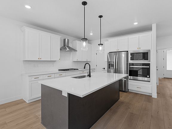 The kitchen has beautiful white wood cabinetry.