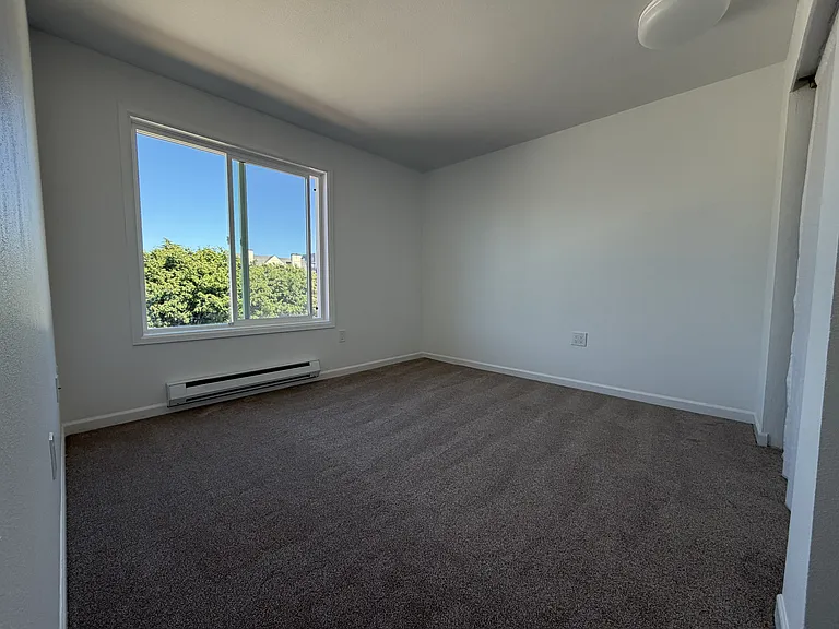 Bedroom 2, brand new carpet, light fixture, and thermostat