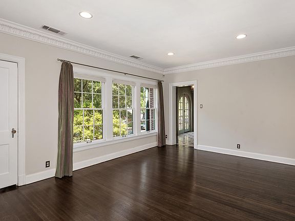 Living room with walk-in closet on the left, leading to the sunroom past the windows. Top down/bottom up adjustable blinds throughout. Newly refinished hardwood floors throughout.