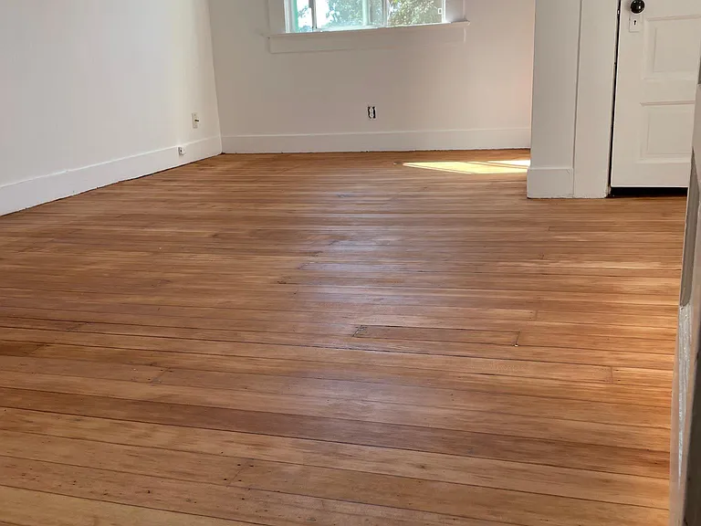 bedroom one with skylight fan and hardwood floors