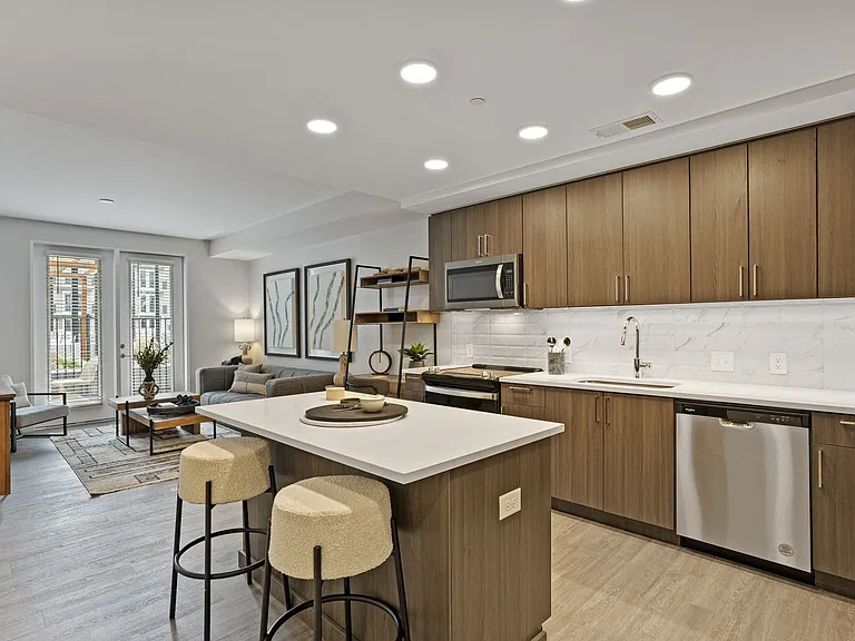 Gourmet Kitchen And Dining Area With White Countertops, Rustic Taupe Cabinets, and Stainless-Steel Appliances
