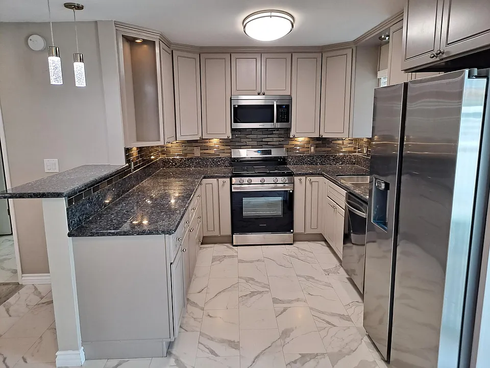 Custom Cabinetry, Granite Countertops and tile backsplash, New Stainless Steel Side by Side refrigerator with ice and water, dishwasher, stove, microwave.