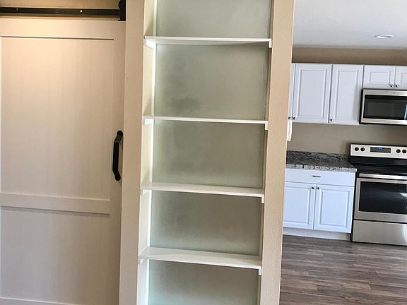 Barn door to additional storage and laundry room. Kitchen on the right side