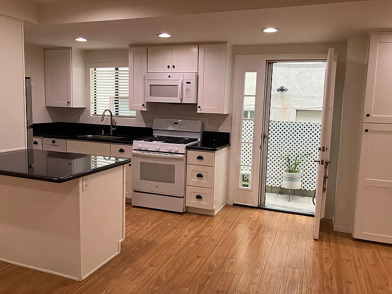 Kitchen: Dishwasher, refrigerator and more cupboards - cabinets right of the right of sink.