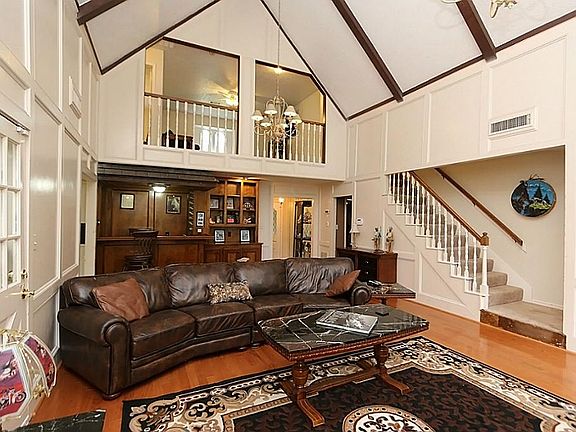 Family room is inviting with soaring ceilings, lots of light, wood floors, wet bar, built-ins and mo