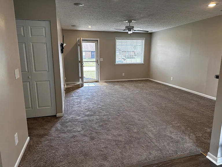 Main living featuring a large window and storm door with southern facing exposure for good amounts of sunlight. This area features a ceiling fan, tile entry landing, in-the-ceiling can lighting, in ceiling speakers, and carpet. The room is appx 21 x 15