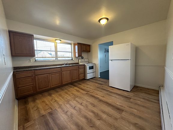 Oversized kitchen with ample cabinets, and space for a smaller table, portable island, or shelves.