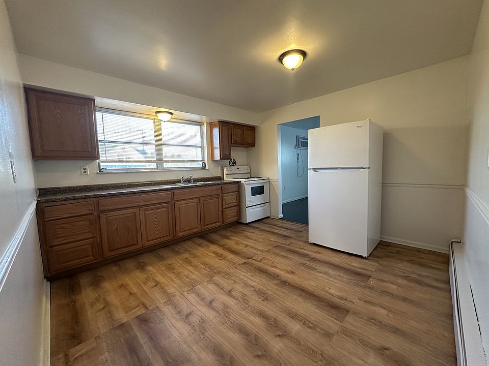 Oversized kitchen with ample cabinets, and space for a smaller table, portable island, or shelves.