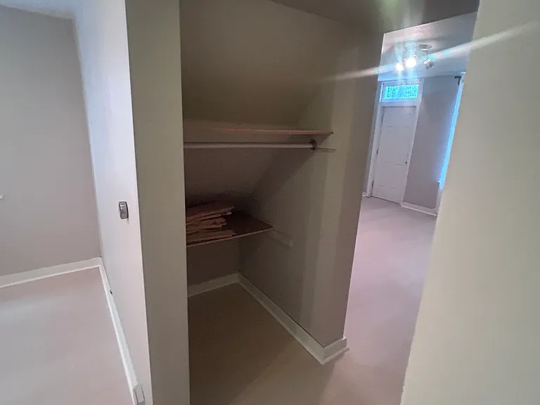 Nook between bedroom and living room has half-height hanging space.