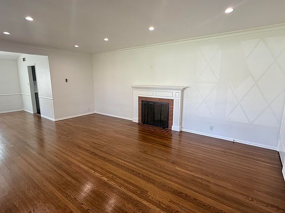 Living room with original hardwood floors and newer recessed lighting.
Plug for TV over fireplace.