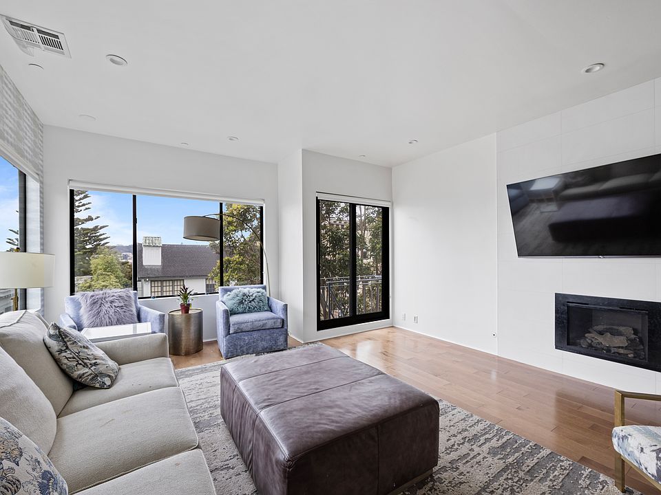 Main living room with beautiful views and sunlight, plus fireplace.