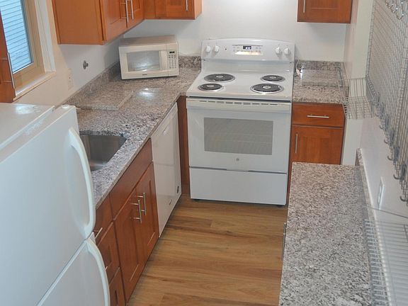 Completely remodeled kitchen with new cabinet, granite counter tops, wood floors, range with self-cleaning oven, dishwasher, frost free refrigerator and wall hanging grid.