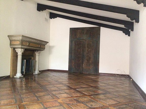 living room/dining room with wood beamed cathedral ceiling, french and stained glass doors, leading to outside patio wood and tile floors, massive fireplace