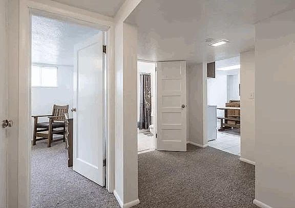 Hallway view of bedroom, bathroom and kitchen area.