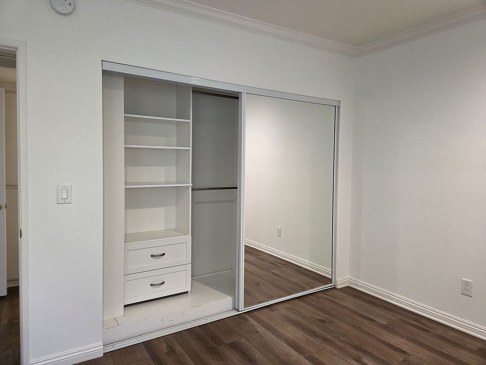 Bedroom with mirrored sliding doors and closet organizers