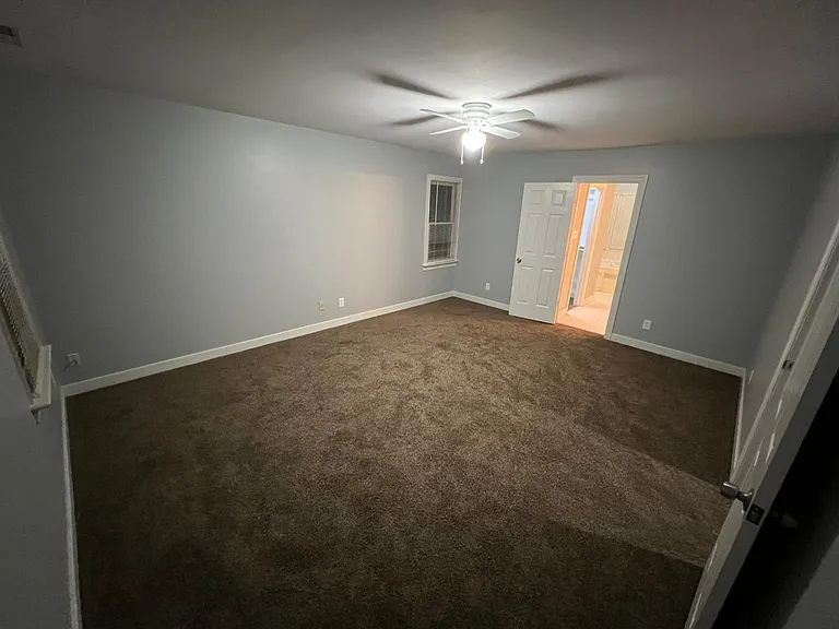 Photo of master bedroom, straight ahead is the door to the master bathroom with walk in closet, door pictured to the right is the hallway