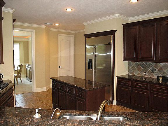 Stainless steel appliances, granite countertops, & island. Two-stage water filtration system. Other features include custom plate rack, spice racks, & appliance garage, custom cabinetry pullout drawers throughout lower cabinetry.