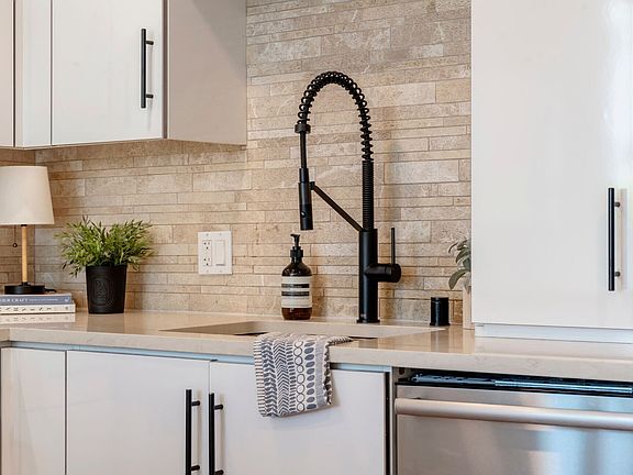 Sink detail
Designer kitchen sink with high-arc pull-down faucet, tile backsplash, and modern finishes_perfect blend of style and practicality.
