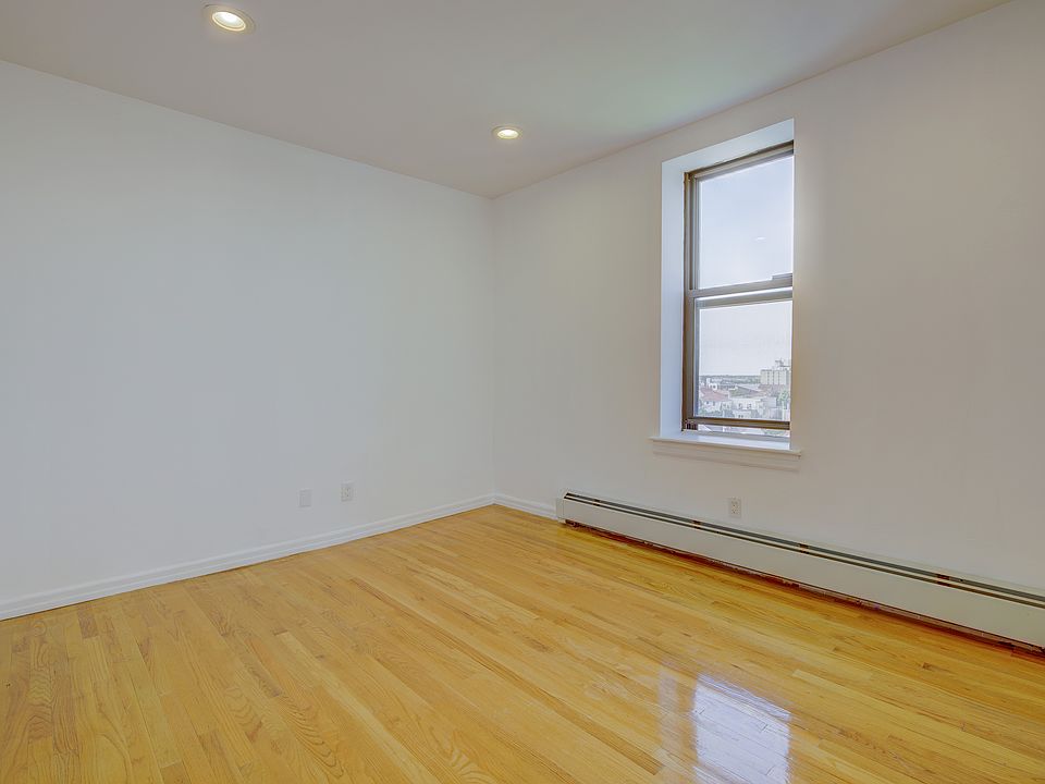 Spare room with a baseboard heating unit, light wood-style flooring, and recessed lighting