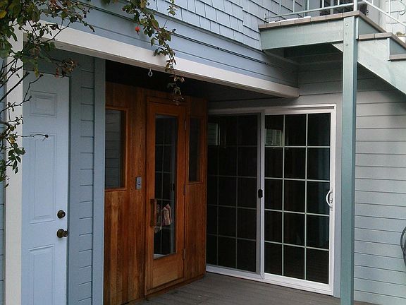 Entrance through sliding glass door, shared laundry behind white door