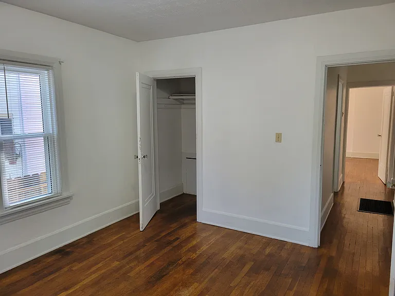 Master bedroom leading to walk-in closet and hallway to bathroom and bedrooms.