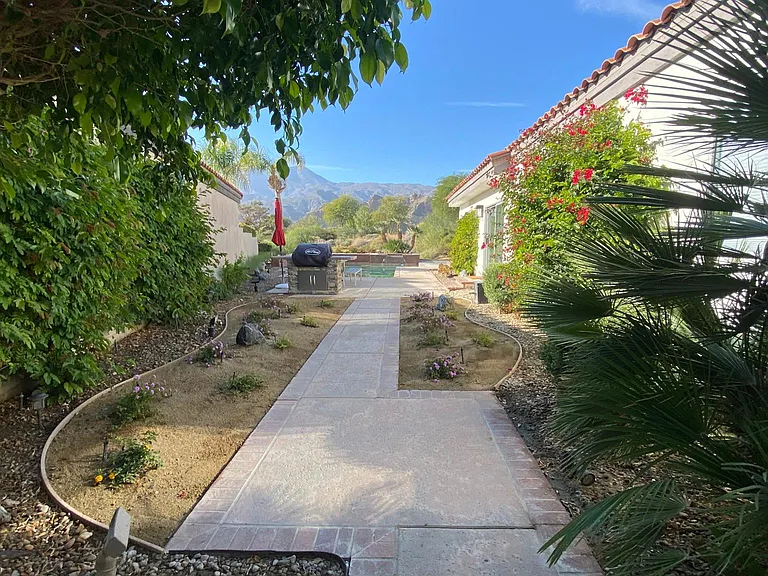 Private side yard with BBQ and pool in background