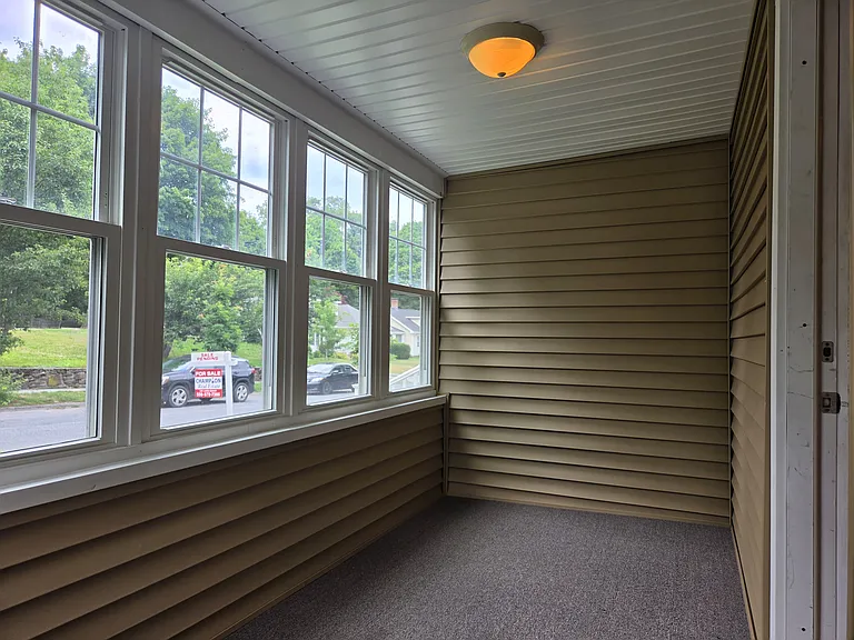 Enclosed sunroom that makes a great home office, reading room, or additional living space for a home office, reading room or additional living space.