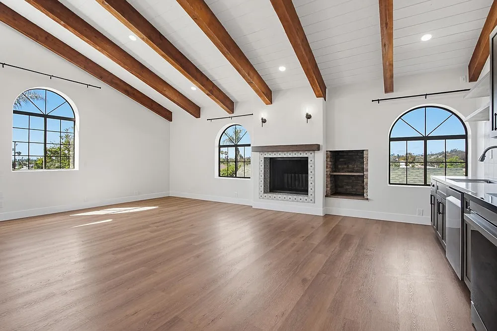 Open Concept kitchen, dining, and living grand space. Features Wood beam vaulted ceiling, fireplace, luxury vinyl floors, arched windows, recessed lighting, sconce mood lighting - 208 W 9th Ave
