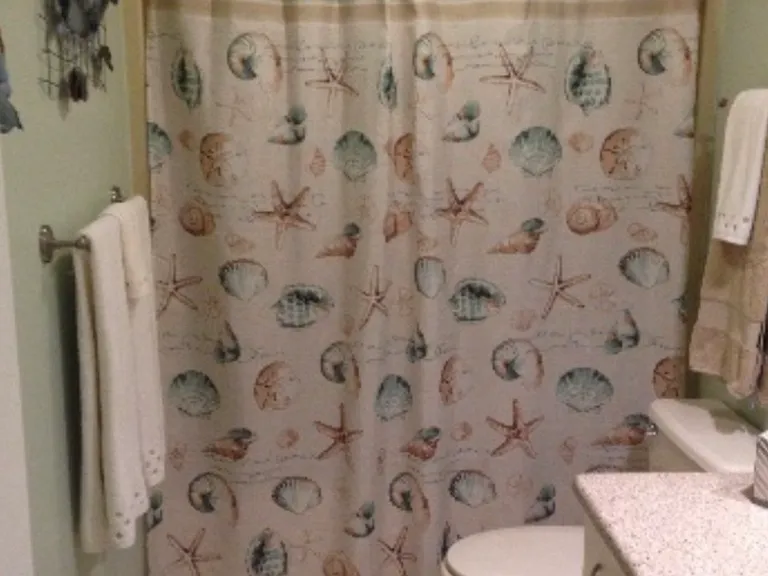 Main bathroom has granite countertops and a shower/bathtub.