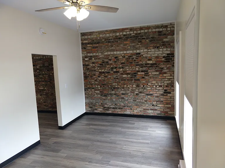 Bedroom facing the north wall and entry door.
