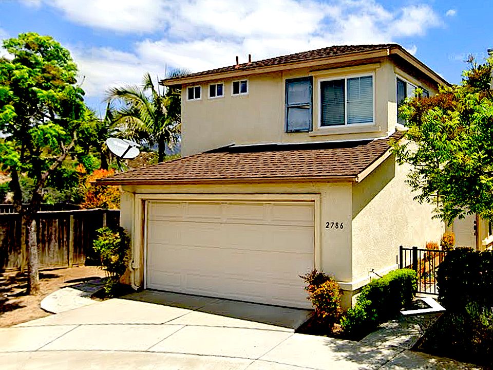 House garage access amid leafy surroundings. Part of an HOA tract.