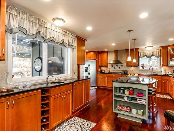 From the living room, we circle into this large and beautifully remodeled kitchen. As you can see, there is certainly no lack of storage or counter space! Did you notice the wet bar by the window on the left?