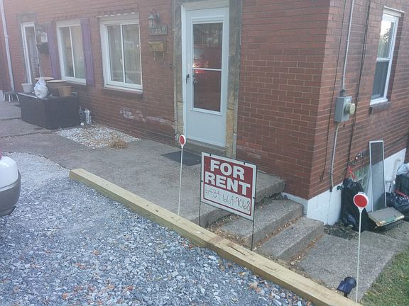 Driveway up to the front of the house. Steps down the side.