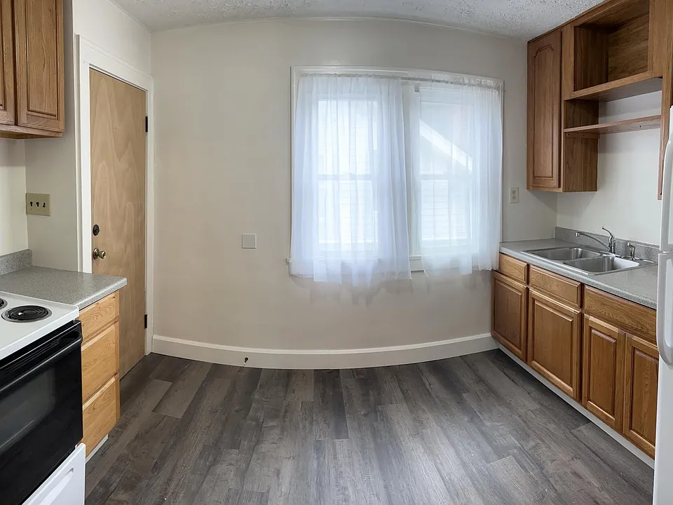 Kitchen with stove, refrigeration, and garbage disposal. New floors.
