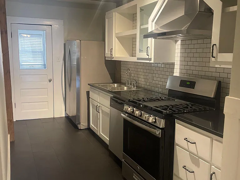 Galley Kitchen - stainless steel appliances and exposed wood beam