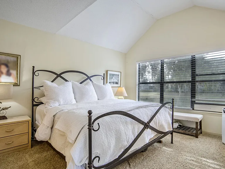 Wake up to water views in this relaxing primary suite, featuring a vaulted ceiling, plush king bed, and a private ensuite bath for ultimate comfort. A true retreat after a day in the sun!