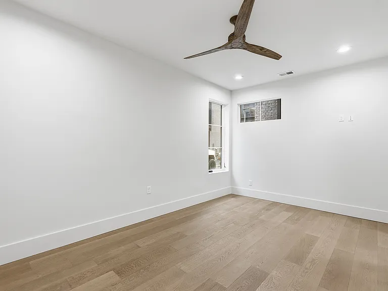 Spacious primary bedroom with modern finishes, recessed lighting, and ensuite access.