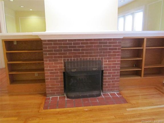Built-in bookshelves surround the fireplace. Mirrors above add light to the room.