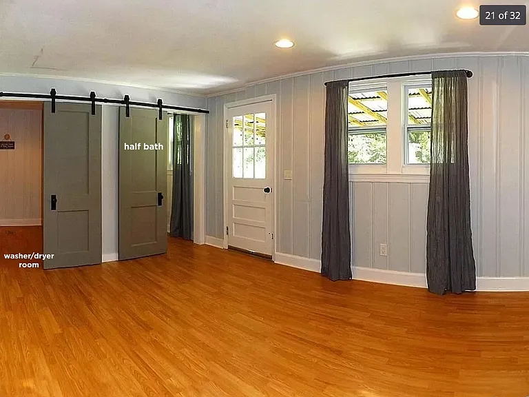 2nd living room at the back of the house with a door leading out to fenced in backyard