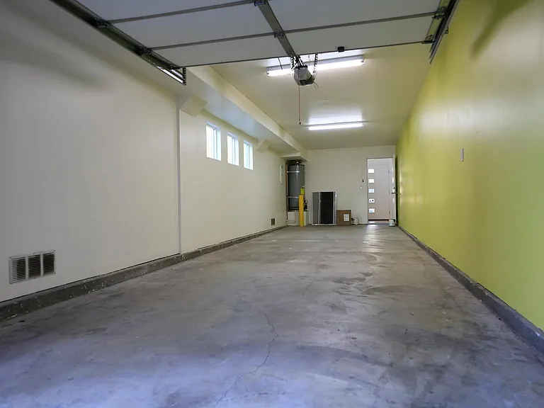 Inside View of Garage with Two Car Tandem Parking and Passage Door Leading into the Apartment