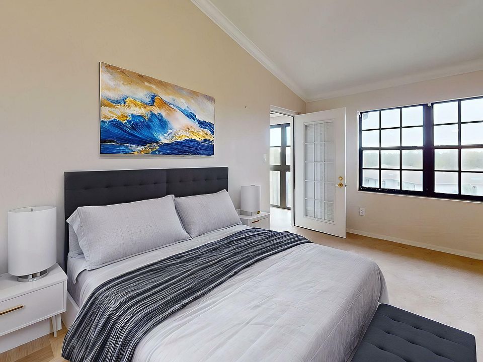 Elegant bedroom with modern decor, plush bed, and large windows offering abundant natural light.