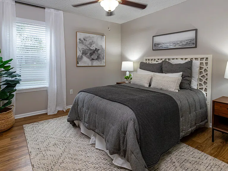 Our spacious bedrooms feature wood-style flooring, a multi-speed ceiling fan, and large windows bringing in natural light.