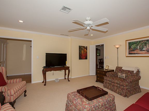 Formal living room with crown molding, LED recessed lighting & Karistan carpet.