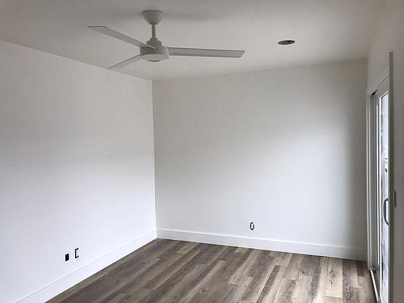 Master bedroom has sliders to the patio, ceiling fan, mirror
