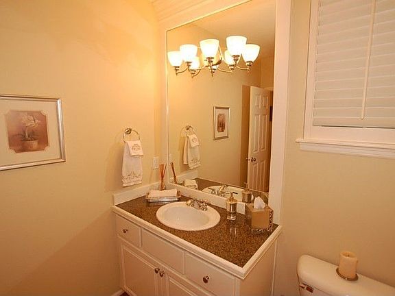 Downstairs half bath with full sized wood wrapped mirror and granite countertops.