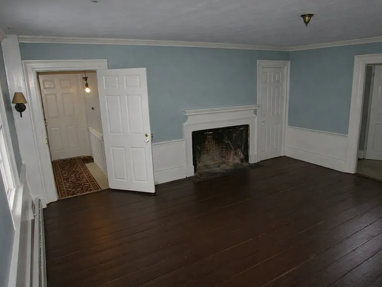 Living Room showing entry door open from the stairway. Note that the fireplace is NOT operational.