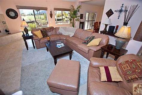 Spacious living room looking out at the pool and golf course